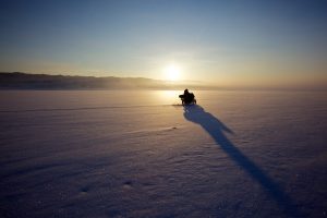 A motorbike riding on snow and ice.