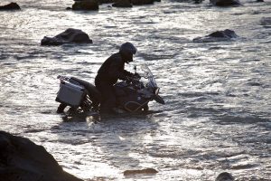 A BMW 1200 GS wades through a river.