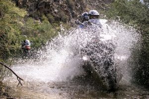 Water splashing up over two motorcyclists on a BMW R1200GS